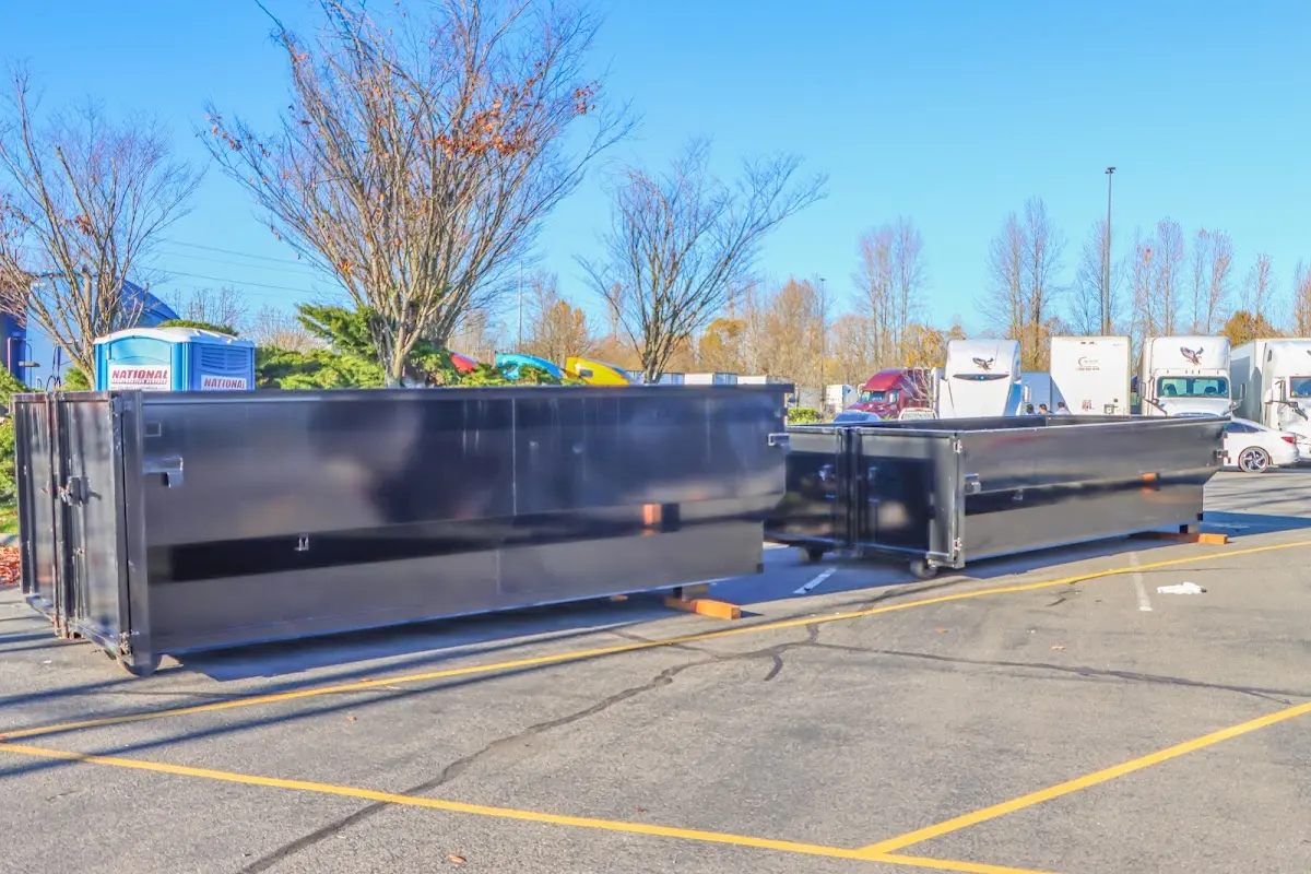 Professional dumpster rental service with roll-off container on residential driveway in Woodward